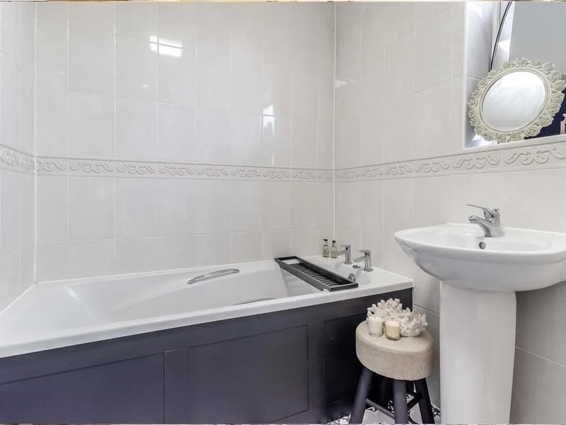 Having a four piece white suite with chrome fittings comprising a panelled bath. Separate double width tiled shower cubicle. Pedestal wash hand basin with mixer tap. Low flush WC. Tiled walls, heated towel rail and obscure double glazed window to the front elevation.