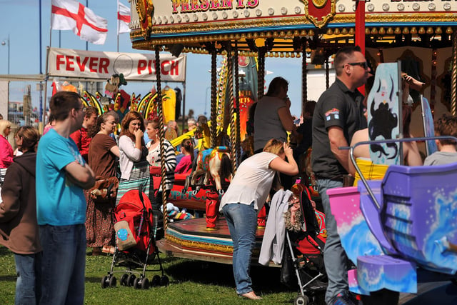 The children are having fun on the rides while their families watch from the sidelines in 2013.