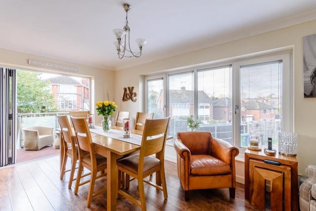 One of the most attractive features of the house is this dining room with its own balcony, which is accessed via bi-fold doors. It is a lovely dual-aspect room, with laminate floor and coving to the ceiling.