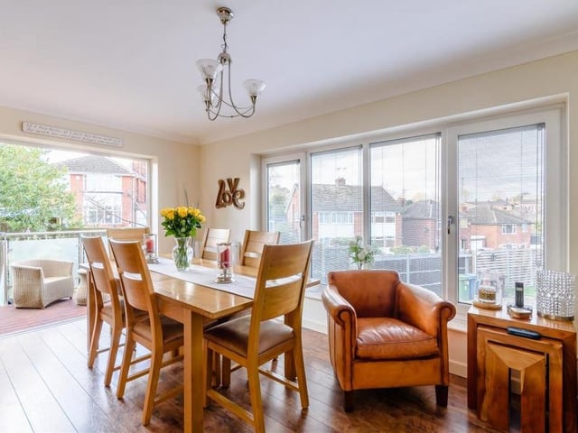 One of the most attractive features of the house is this dining room with its own balcony, which is accessed via bi-fold doors. It is a lovely dual-aspect room, with laminate floor and coving to the ceiling.