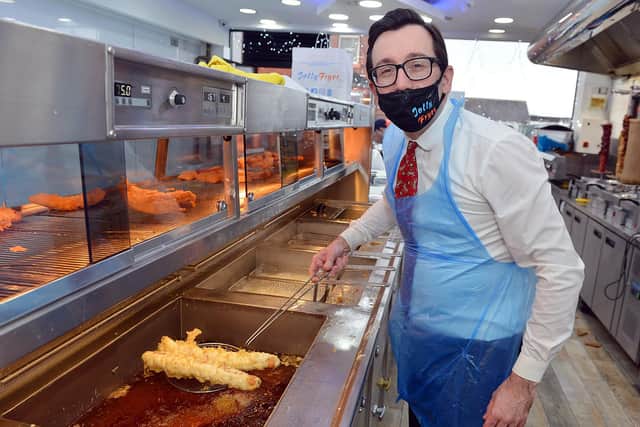 Jolly Frier owner Theo Tsiolas fries up some battered pigs in blankets.