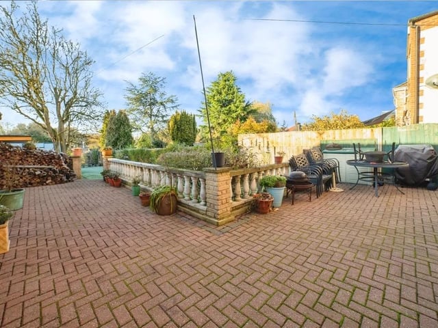The block-paved seating area behind the house is ideal for alfresco dining or quiet afternoons outdoors.