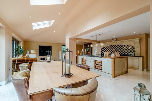 As part of the open-plan kitchen is this dining area, which has a tiled floor and underfloor heating. Other features of the kitchen are a walk-in pantry cupboard, with shelves, and an integrated, full-height fridge with separate full-height freezer.