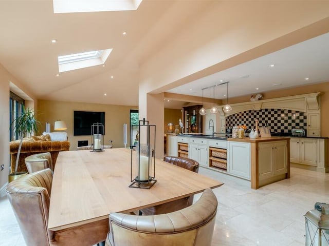 As part of the open-plan kitchen is this dining area, which has a tiled floor and underfloor heating. Other features of the kitchen are a walk-in pantry cupboard, with shelves, and an integrated, full-height fridge with separate full-height freezer.