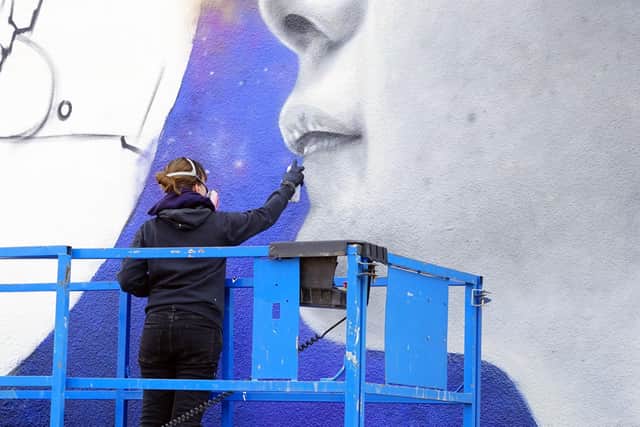 French artist Zabou is seen painting the mural on the building at Sutton.