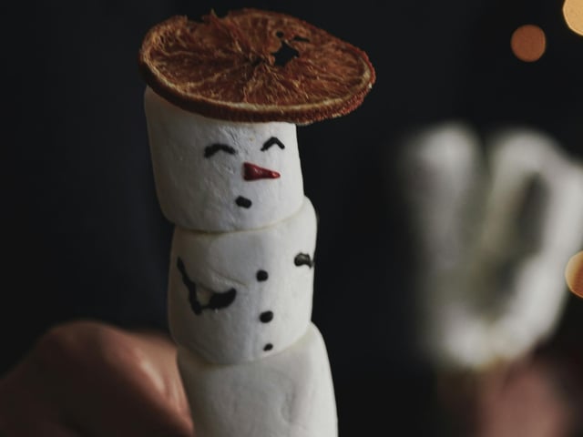 Marshmellow Snowmen: Marshmallow snowmen are a fun, easy, and edible craft perfect for the Christmas holiday, great for both kids' activities and delightful gifts. You will need: Large marshmallows (3 per snowman), mini marshmallows (for the nose, optional), Pretzel sticks (for arms), Mini peanut butter cups or fudge rounds (for hats), mini chocolate chips (for eyes and mouth), Orange sprinkles or a small piece of orange candy (for the nose), white or colored icing in a small squeeze tube to "glue" the parts together, decorative icing (for scarves or earmuffs) and skewers or lollipop sticks (optional, for stability). To assemble the body: Use a dab of icing between each marshmallow to "glue" three large marshmallows together in a stack. For extra stability, you can insert a skewer or lollipop stick vertically through the centre of all three marshmallows before adding the icing. Break pretzel sticks into smaller pieces and gently push them into the sides of the middle marshmallow to create arms. Use a dab of icing to attach a mini peanut butter cup or fudge round to the top of the top marshmallow as the snowman's hat. Use the icing tube to dab small amounts of icing where you want the eyes, mouth, and buttons. Place mini chocolate chips in the icing dots for the eyes and buttons. For the mouth, you can use several mini chocolate chips in a smile shape. To add a nose use a small piece of orange candy or a single orange sprinkle for the carrot nose, secured with a tiny bit of icing. Add accessories by using colored icing to pipe a "scarf" around the neck where the top and middle marshmallows meet.
