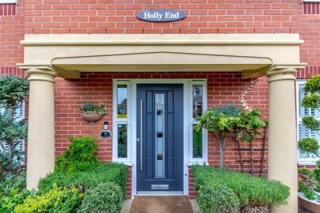 The impressive entrance to Holly End, complete with a large, open-fronted storm porch, stone pillars at each end and a contemporary, composite front door by Rockdoor.