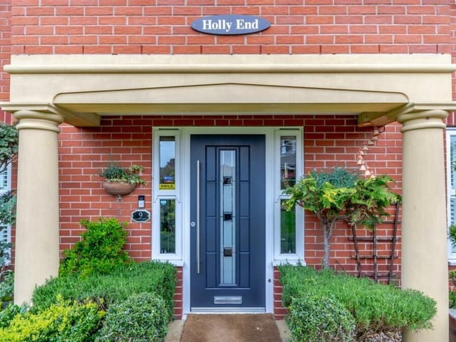 The impressive entrance to Holly End, complete with a large, open-fronted storm porch, stone pillars at each end and a contemporary, composite front door by Rockdoor.
