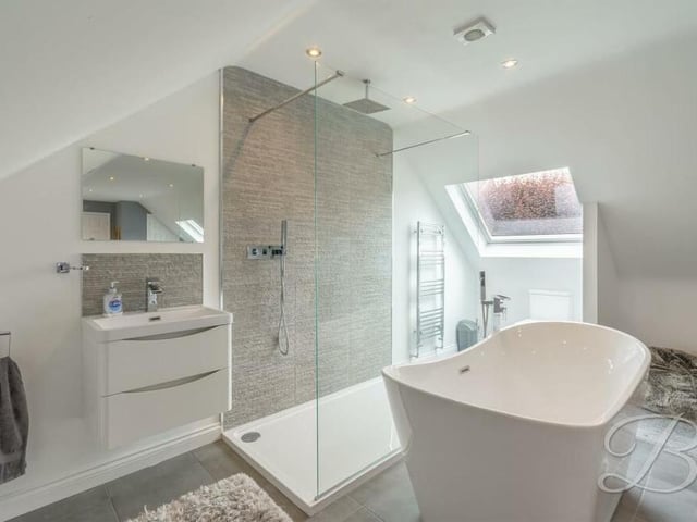 Here is a close-up of the open bathroom area in the master bedroom. It includes a free-standing bath with waterfall tap, spacious walk-in shower cubicle, low-flush WC, vanity wash hand basin, chrome, heated towel-rail and downlights.