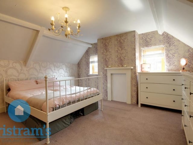 Let's move upstairs now and take a look at the first bedroom, which is currently being used as the master. The floor is carpeted, while there is plenty of storage space. Two uPVC windows overlook the side of the cottage.