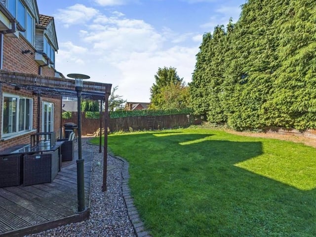 Moving outside now, and here is a view of the pleasant back garden. It combines a lawn with a covered, decked area, ideal for sitting out or enjoying barbecues during the summer.