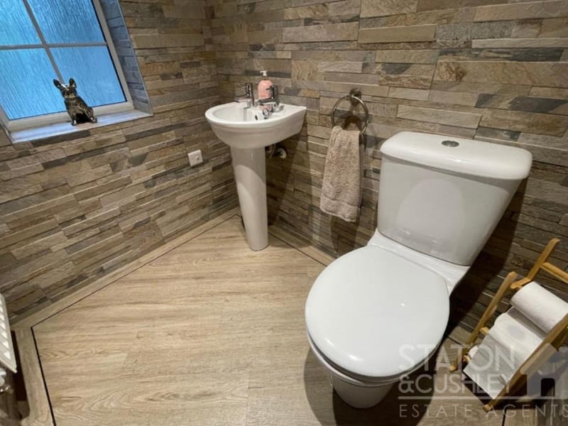 There is a handy downstairs toilet at the Kirkby property. It includes a low-level WC, pedestal sink, tiled walls and LVT flooring.