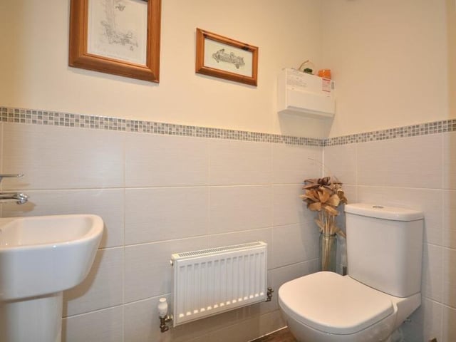 Also on the ground floor of the £365,000 property can be found a utility room, with space for a washing machine, and also this toilet, complete with a wash hand basin with mixer tap, and a low-flush WC.