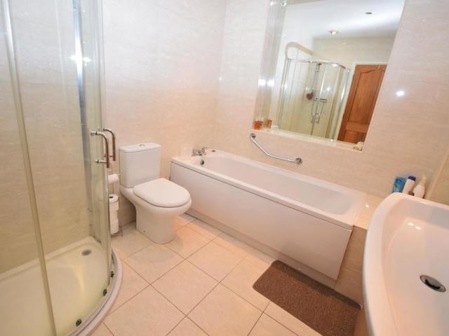As well as the en suite facilities, the first floor hosts this sparkling family bathroom. It consists of a panelled bath, separate shower cubicle, low-flush WC, wash basin in vanity unit, chrome heated towel-rail, tiled flooring and tiled walls.