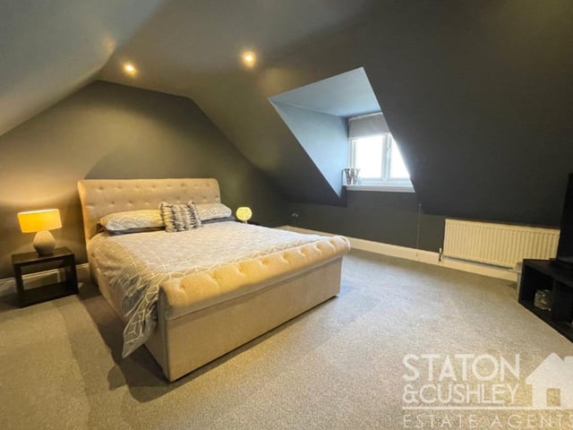 One one side of the landing on the second floor is a bathroom, while on the other is this commanding master bedroom, with a window facing the back of the house.