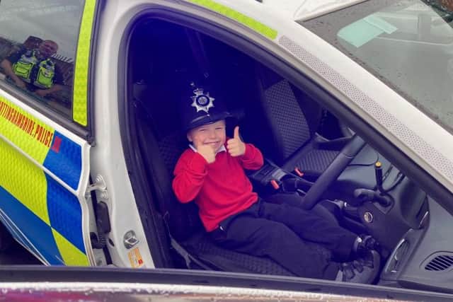 Leon Wood sits in a police car.
