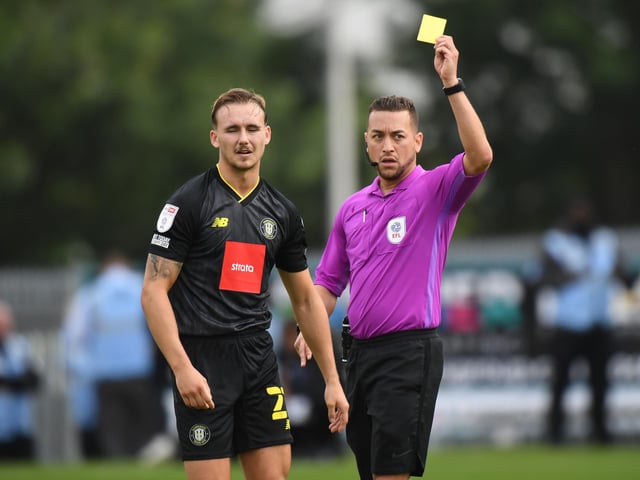 Referee Paul Howard shows a yellow card to Jack Diamond. Harrogate had two players sent off this season and 60 yellows.