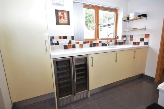 Just off the kitchen is this useful utility room, which includes a wine cooler to keep your bottles chilled. Further base unit storage is housed here, along with a Corian worktop, and sink and drainer.