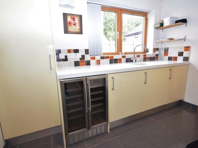 Just off the kitchen is this useful utility room, which includes a wine cooler to keep your bottles chilled. Further base unit storage is housed here, along with a Corian worktop, and sink and drainer.