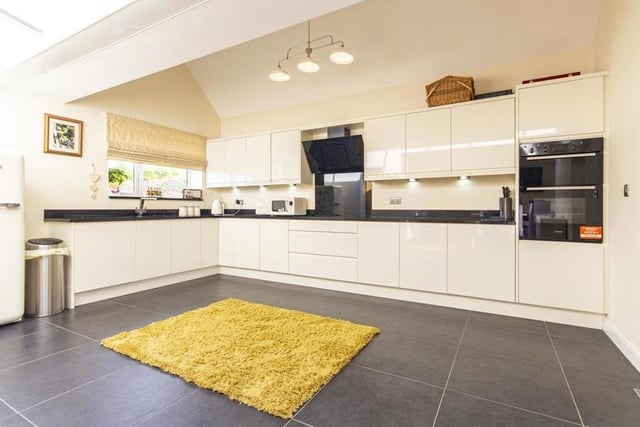 Our tour of the ground floor of the Glapwell bungalow begins in the open-plan kitchen/dining room. The kitchen is a contemporary room, fitted with a range of cream, high-gloss wall, drawer and base units with under-unit lighting and complementary quartz work surfaces.