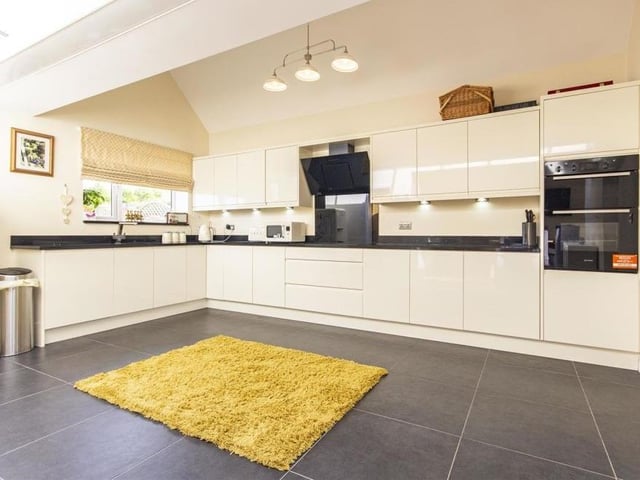 Our tour of the ground floor of the Glapwell bungalow begins in the open-plan kitchen/dining room. The kitchen is a contemporary room, fitted with a range of cream, high-gloss wall, drawer and base units with under-unit lighting and complementary quartz work surfaces.