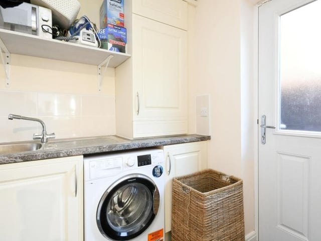 This handy utility room, just off the kitchen, has space and plumbing for a washing machine.