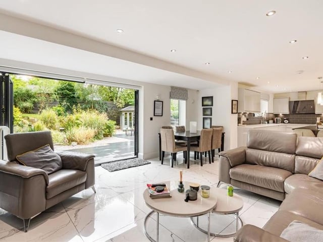 The dominant room on the ground floor is this open-plan living room and dining kitchen. It is superbly appointed, with bi-fold doors in the living area leading out to the back garden, and there is ample space for a dining table.