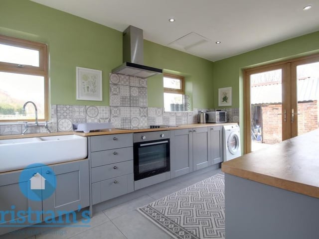 The stylish kitchen is an open space, featuring a wealth of base and wall cupboards, complete with under-unit lighting. There are solid work surfaces throughout, plus space for an oven cooker, with ceramic hob above.