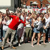 England fans celebrating in the sun. They were watching England's first world cup game of 2006 on a huge screen in Mansfield's Swan Inn yard.