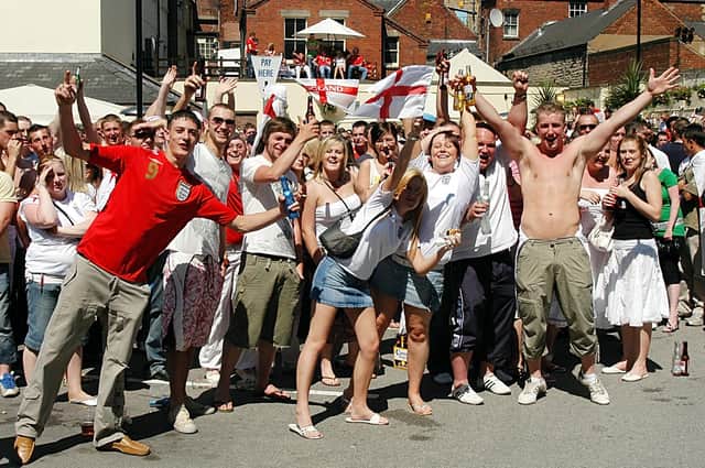 England fans celebrating in the sun. They were watching England's first world cup game of 2006 on a huge screen in Mansfield's Swan Inn yard.