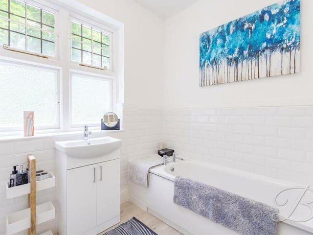 Here is another bathroom on the first floor of the Mansfield house. It consists of a panelled bath, wash hand basin, tiling and under-stairs storage cupboard.