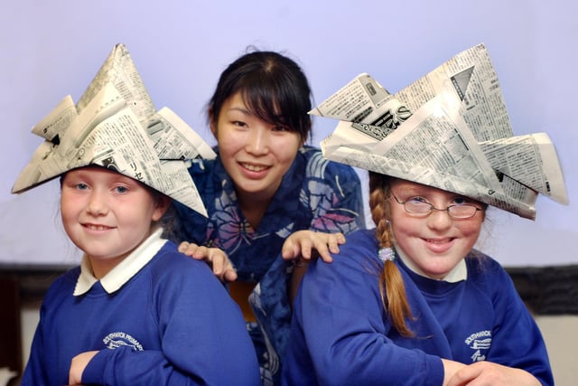 Jordan Devlin, 9, and Rebecca Anderson, 10, show off their hats they made in an origami session with Saki Kawai, a student from Durham University.