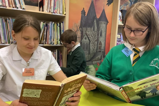 Bella, Alfie and Maria, school librarians, enjoying a good book in the school library