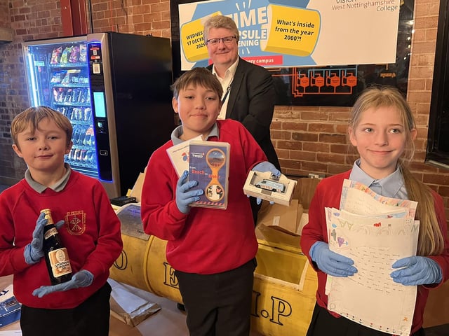 St Peter's Primary pupils Logan, Leo and Abbie with Gavin Peake and items from the capsule.