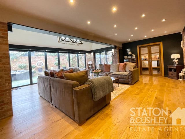 The lounge from a different angle, showing bi-folding doors that open out to the rear garden.