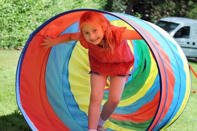 Poppy Scott, 6, emerges from an obstacle course tunnel.