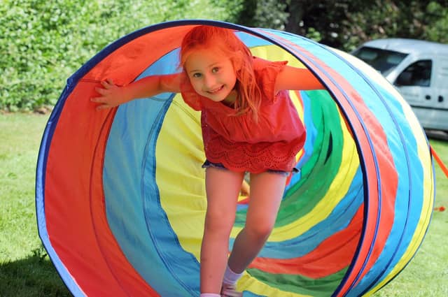 Poppy Scott, 6, emerges from an obstacle course tunnel.