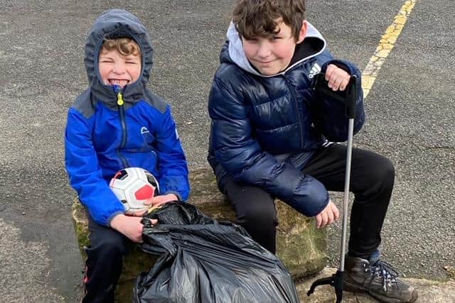Volunteer litter-pickers, 10-year-old Olly Whitsed and his five-year-old brother Joey, with the rubbish they collected as part of the Just Bin It campaign.