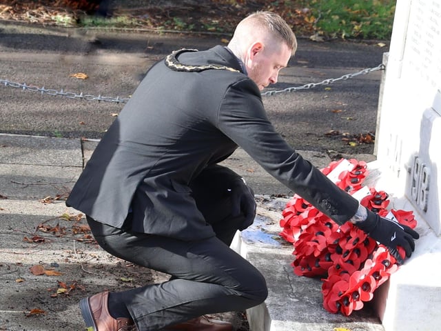 "We Will Remember Them". Cllr Dale Grounds lays a wreath of poppies at St Mary's Cenotaph