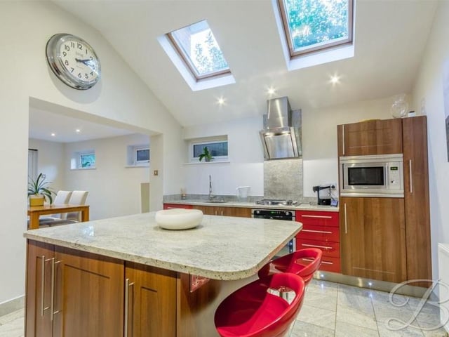 Let's begin our tour of the interior of the Harlow Avenue house in the kitchen, which is fitted with modern units, including within a centre island. A vaulted ceiling comes with remote-controlled Velux windows.