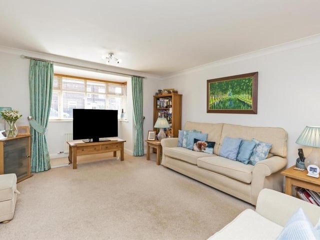From the dining room, double doors lead to this large and lovely lounge, with its carpeted floor and electric feature fire place. The uPVC double-glazed bay window overlooks the front of the £400,000 property.