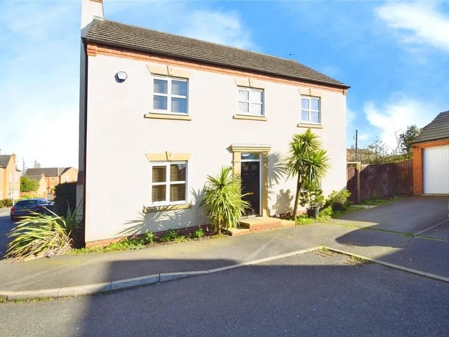 The property sits on a corner plot with a driveway leading to the single garage.