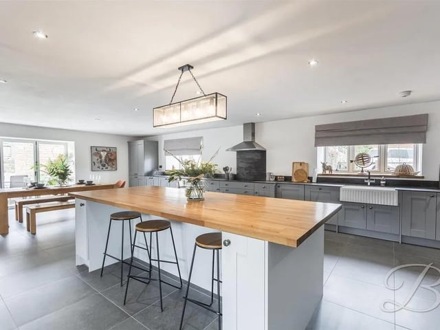 The kitchen is thoughtfully fitted with a range of high-quality, matching cabinetry and a large central island that doubles as a breakfast bar.