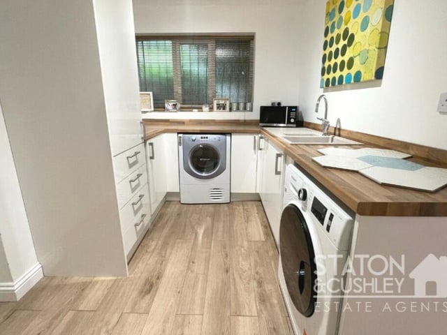 Just off the kitchen is this handy utility room, which has space for a washing machine and tumble dryer. It boasts fitted base units, roll-edge work surfaces, sink and drainer with mixer tap.