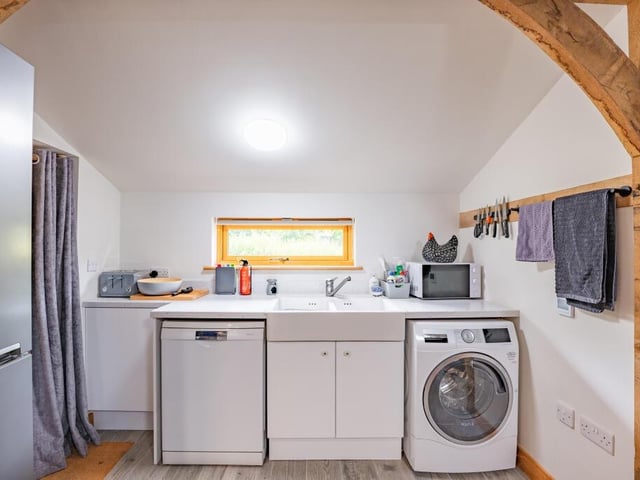 The living space within the annexe includes a lounge, dining area and this kitchen, which has space for a washing machine.