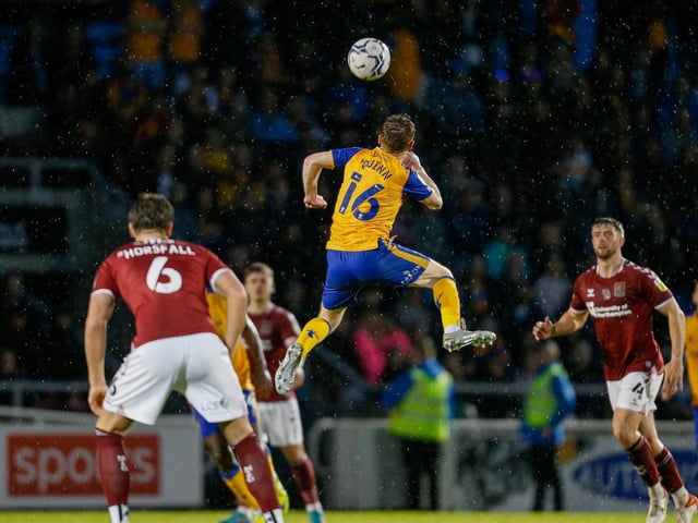 Mansfield Town midfielder Stephen Quinn jumps high to win the header.