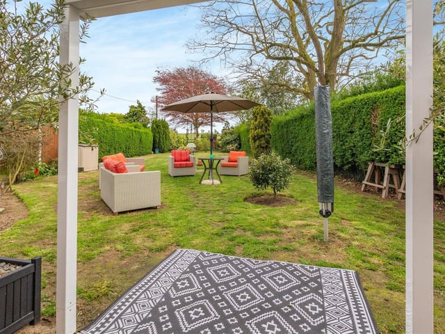 The back garden at Greenways includes a pleasant seating area.