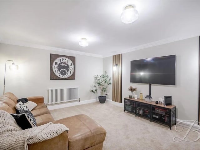 The delightful living room, bathed in natural light is perfect for relaxing or entertaining guests.