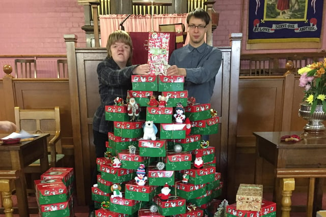  Amy Truscott and Liam Wright with the shoeboxes collected for  Operation Christmas Child, which was celebrated with a Christmas Tree made up of shoeboxes at The Gospel Mission Congregational Church in Chesterfield.