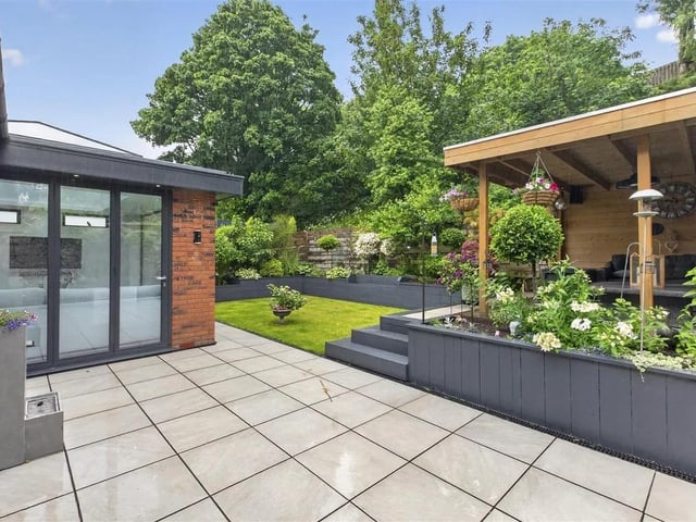 The stunning garden is an oasis of tranquility with extensive raised beds with plants and shrubs and a built-in seating area at the end.